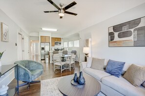 Uma sala de estar moderna com sofá, mesa de centro e área de jantar com cadeiras e mesa.