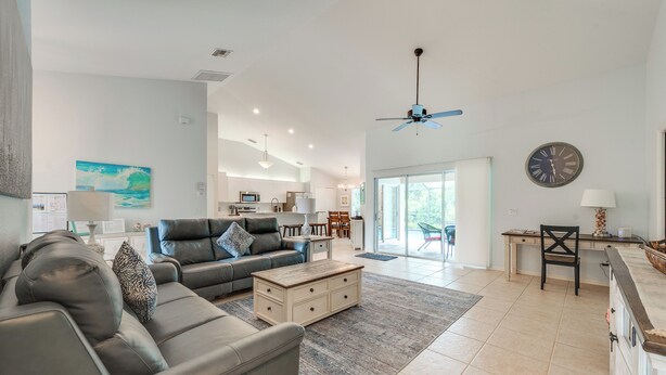 Uma sala de estar moderna com um sofá, mesa de centro e uma área de jantar com mesa e cadeiras.