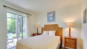 Une chambre avec un grand lit, deux tables de chevet avec des lampes, une tête de lit en bois, une fenêtre avec des rideaux et un tableau encadré au mur.