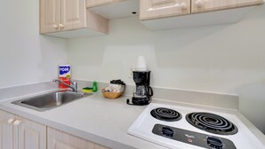 Une cuisine équipée d’un évier, d’une cuisinière et de placards.