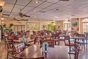 A spacious restaurant with multiple tables and chairs, ceiling fans, and large windows. - Bright Naples Vacation Rental: Close to Waterfront (Naples)