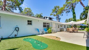 Uma casa com um pátio, uma piscina pequena e gramado.