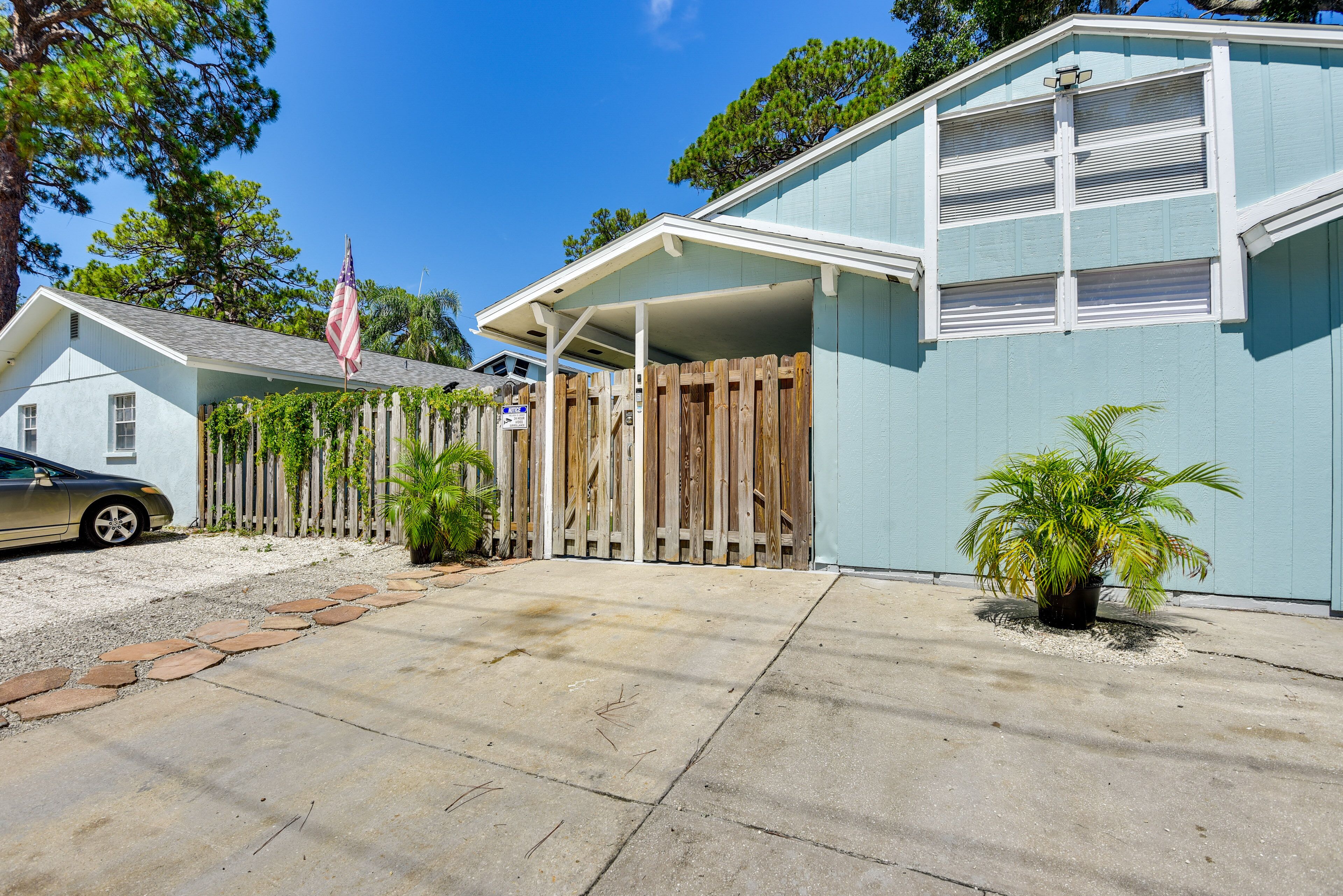 A residential house with a garage, a wooden fence, and a potted plant.