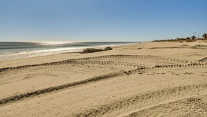 A beach with footprints and a large rock formation. - Swim, Soak + Play: Myrtle Beach Resort Condo! (Myrtle Beach)