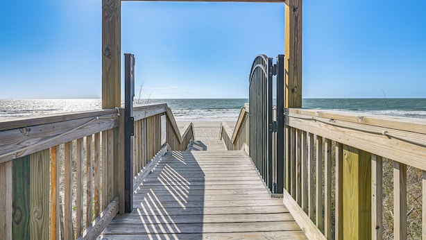 A wooden boardwalk leading to a beach with a clear sky. - Swim, Soak + Play: Myrtle Beach Resort Condo! (Myrtle Beach)