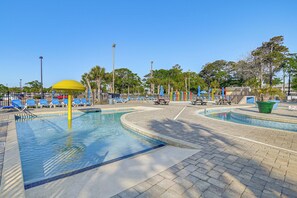 A swimming pool with blue lounge chairs and a yellow umbrella. - Swim, Soak + Play: Myrtle Beach Resort Condo! (Myrtle Beach)