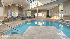 An indoor swimming pool with a tiled deck, a roofed area with tables and chairs, and a clear view of the sky. - Swim, Soak + Play: Myrtle Beach Resort Condo! (Myrtle Beach)