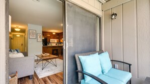 A cozy living area with a grey sofa, a blue armchair, and a dining table. - Myrtle Beach Vacation Rental: 1 Mi to Apache Pier! (Myrtle Beach)