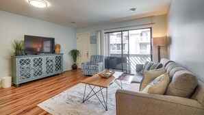 A living room with a sofa, armchair, TV, and a wooden coffee table. - Myrtle Beach Vacation Rental: 1 Mi to Apache Pier! (Myrtle Beach)