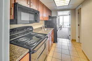 Een oven, een kookplaat, een blender, kookgerei, borden en bestek