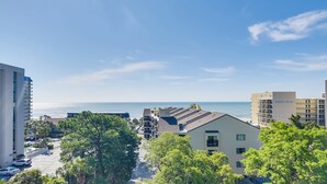 Ein Küstenwohngebiet mit modernen Gebäuden, blauem Himmel und Blick auf den Ozean.