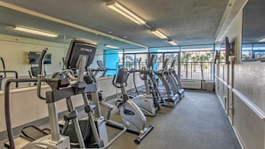 A gym with treadmills, ellipticals, and a TV screen. - Oceanfront Studio w/ Pool Access in Myrtle Beach! (Myrtle Beach)