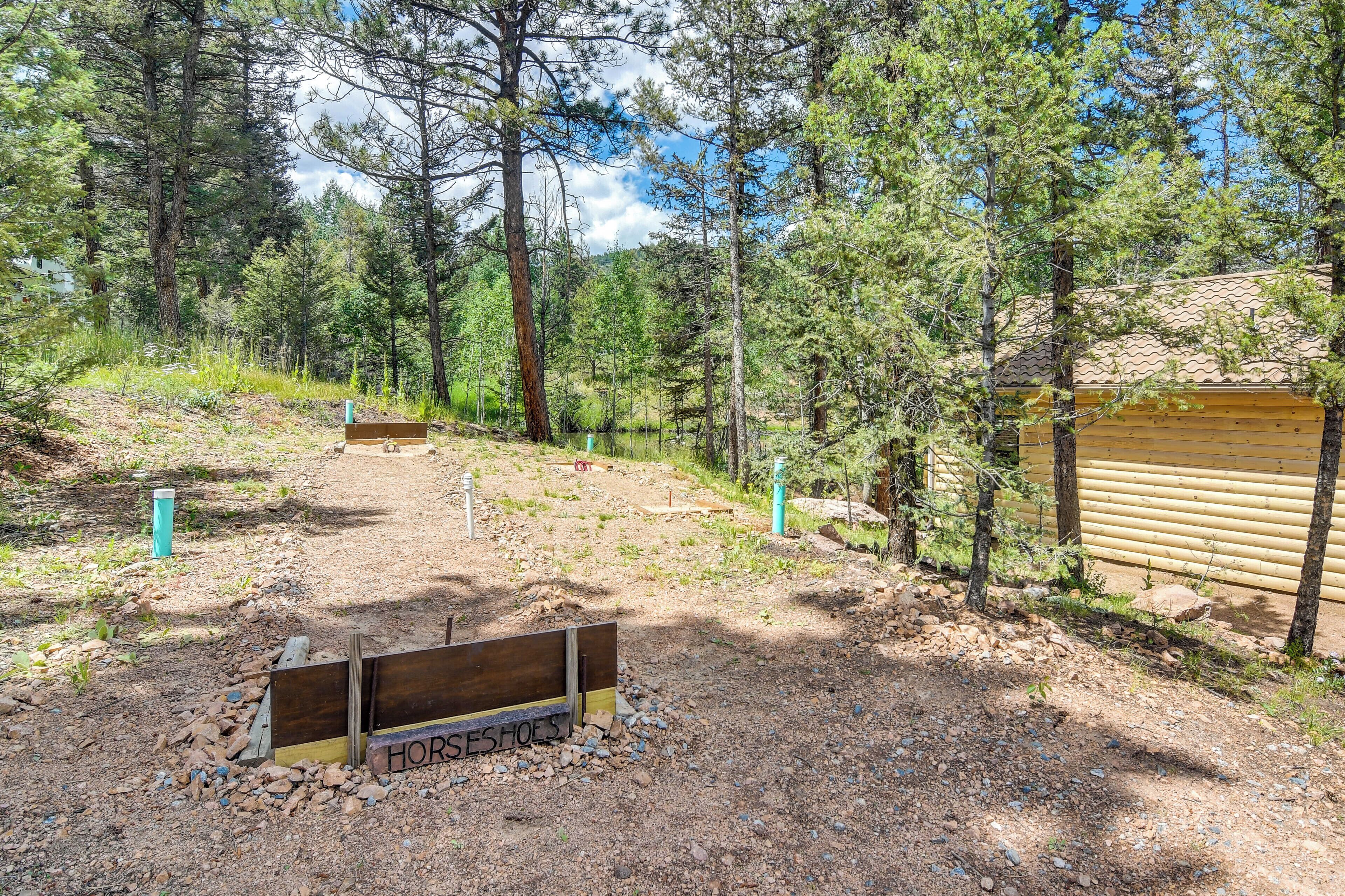 Una cabaña de madera con un sendero de tierra que la lleva, rodeada de árboles.