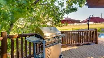 Enjoy al fresco dining and outdoor cooking on this deck with a barbecue grill and poolside umbrella.