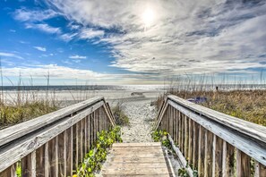 A wooden boardwalk leading to a beach with a clear sky and distant horizon. - Private Deck & Pool Access: Myrtle Beach Getaway! (Myrtle Beach)