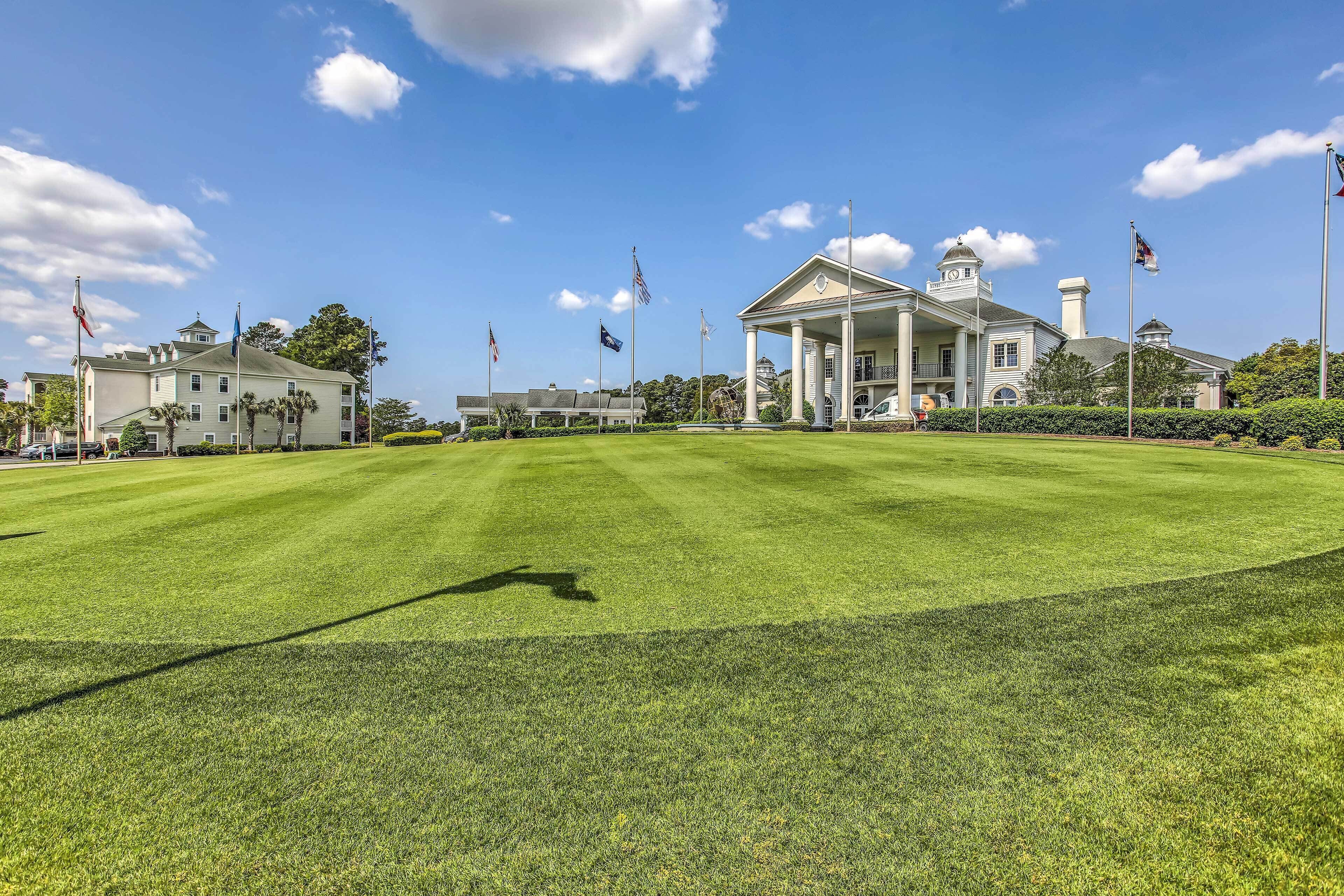 A large, well-maintained lawn with a grand building featuring a central pavilion and multiple flags.