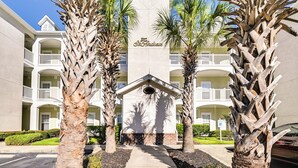 A hotel with a central entrance, multiple balconies, and palm trees. - ~ 6 Mi to Ocean w/ Pool & Golf: Myrtle Beach Condo (Myrtle Beach)