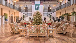 A spacious lobby with a central Christmas tree, multiple seating areas, and a staircase connecting floors. - Naples Resort Retreat w/ Heated Pool Access! (Naples)