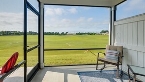 Een kamer met een grote glazen deur die uitkomt op een grasveld.