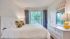 A bedroom with a bed, a dresser, a mirror, and a window with curtains. - Kiawah Island Vacation Rental: Walk to Beach! (Kiawah Island)