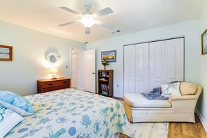 Une chambre à coucher comprenant un lit, une chaise, un bureau, une bibliothèque et une armoire.