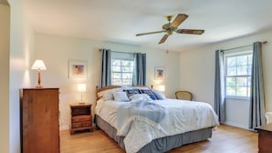A bedroom with a bed, wooden nightstands, a ceiling fan, and a window with curtains. - Bradenton Retreat Near Beaches w/ BBQ & Fire Pit (Bradenton)