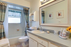 A bathroom with a bathtub, toilet, sink, and a large mirror. - Bradenton Retreat Near Beaches w/ BBQ & Fire Pit (Bradenton)