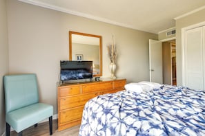 A bedroom with a bed, a dresser, a chair, a TV, and a mirror. - Walk to Coast: North Myrtle Beach Condo w/ Pool! (North Myrtle Beach)