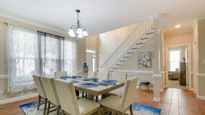 A dining area with a wooden table, beige chairs, and a blue and white rug. - Lakefront Raleigh Retreat ~ 7 Mi to Downtown! (Raleigh)