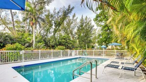 A rectangular swimming pool with a white deck and a blue border, surrounded by a white fence. - Longboat Key Vacation Rental: Direct Beach Access! (Longboat Key)