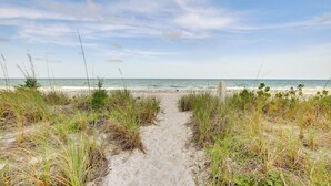 A sandy path leading to a beach with sparse vegetation. - Longboat Key Vacation Rental: Direct Beach Access! (Longboat Key)