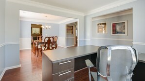 A modern kitchen with a large island, wooden chairs, and a dining table. - Raleigh Home w/ Modern Adjustable Sleeping System (Raleigh)