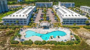 A resort with multiple buildings, a central pool area, and a view of the ocean. - Walk to Beach! Gulf Shores Escape w/ Indoor Pool (Gulf Shores)