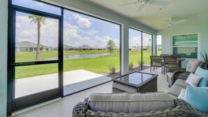 A spacious room with large sliding glass doors leading to a patio area. - Home w/ Lanai + Community Perks in The Villages! (Okahumpka)