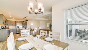 A modern kitchen with a dining area set for a meal. - Home w/ Lanai + Community Perks in The Villages! (Okahumpka)