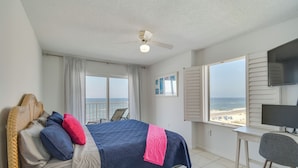 A bedroom with a bed, a desk, and a view of the beach. - Beachfront Condo in Gulf Shores w/ Pool Access! (Gulf Shores)