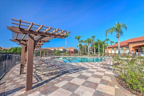 A pool area with a pergola, lounge chairs, and palm trees. - 12 Mi to Disney: Family Home in Davenport (Davenport)