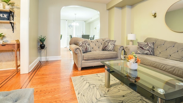 A living room with a sofa, coffee table, and a dining area in the background. - Baltimore Vacation Rental - Near JHU & Art Museum! (Baltimore)