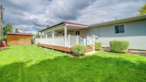 A single-story house with a covered porch and a well-maintained lawn.