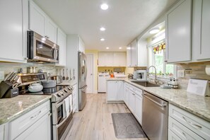 A modern kitchen with white cabinets, stainless steel appliances, and a granite countertop. - Dog-friendly Idaho Falls Vacation Rental w/ Yard! (Idaho Falls)