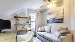 A modern living room with a sofa, a television, and a ceiling fan. - 3 Mi to Dtwn Springfield: Winter Retreat w/ Office (Springfield)