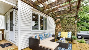 A covered porch with a wicker sofa, a glass table, and a patterned rug. - 3 Mi to Dtwn Springfield: Winter Retreat w/ Office (Springfield)