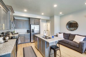 A modern kitchen with granite countertops, stainless steel appliances, and a central island. - Garden City Townhome, Close to Parks + Downtown! (Garden City)