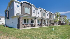 A modern townhouse with a covered patio, stone accents, and a well-maintained lawn. - Garden City Townhome, Close to Parks + Downtown! (Garden City)