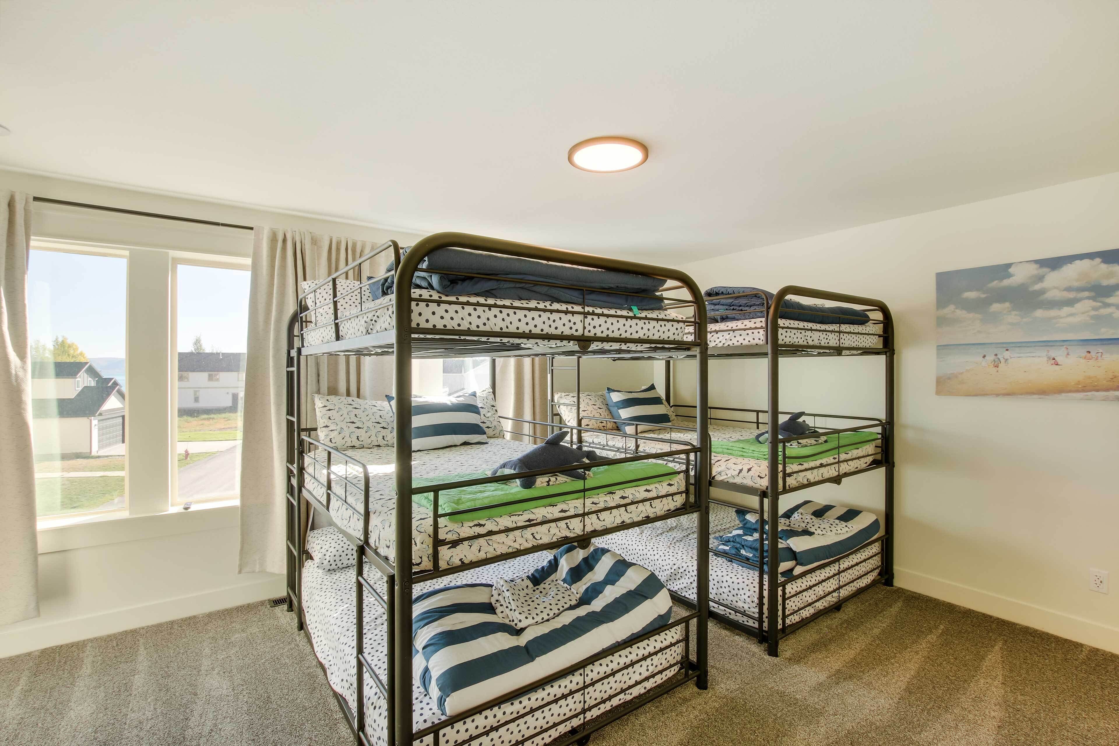 Une chambre avec un lit superposé donnant sur les maisons du quartier.