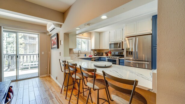 A modern kitchen with a central island, bar stools, and stainless steel appliances. - Incline Village Retreat Near Skiing & Beaches (Incline Village)