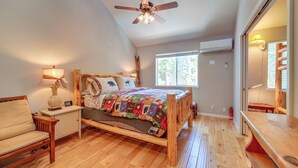 A bedroom with a wooden bed, a nightstand, a lamp, a ceiling fan, and a window with blinds. - Incline Village Retreat Near Skiing & Beaches (Incline Village)