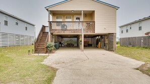 A two-story house with a covered front porch, a wooden staircase, and a fenced backyard. - Nags Head Vacation Rental w/ Hot Tub: Near Beach! (Nags Head)