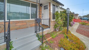A residential house with a front porch, a staircase, and a garden with various plants. - Seaside Vacation Rental w/ Patio Near Monterey Bay (Seaside)