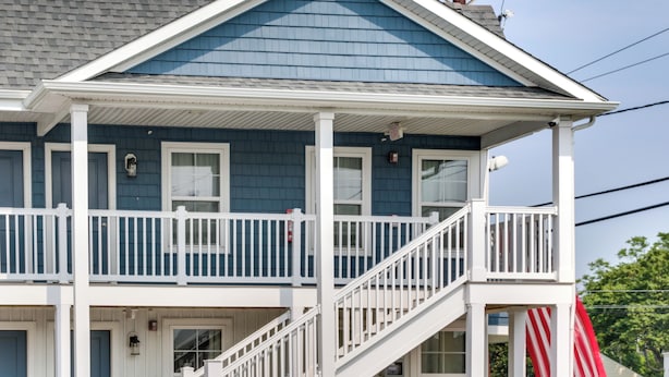A two-story building with a balcony and a staircase. - Community Pool Access: Rehoboth Beach Unit! (Rehoboth Beach)